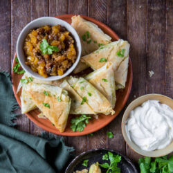 Baked beef samosa on a plate paired with mango chutney.