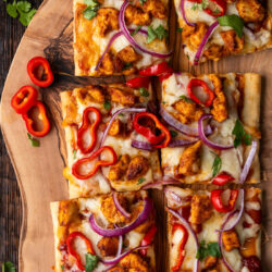 Delight in these colorful BBQ Chicken Flatbreads. Savory chicken and veggies on top of a cheesy, BBQ coated flatbread.