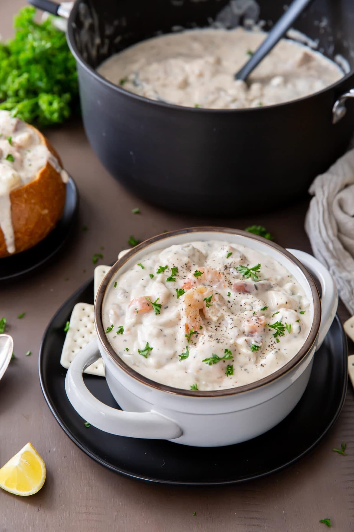 Creamy seafood chowder in a white bowl with a handle.
