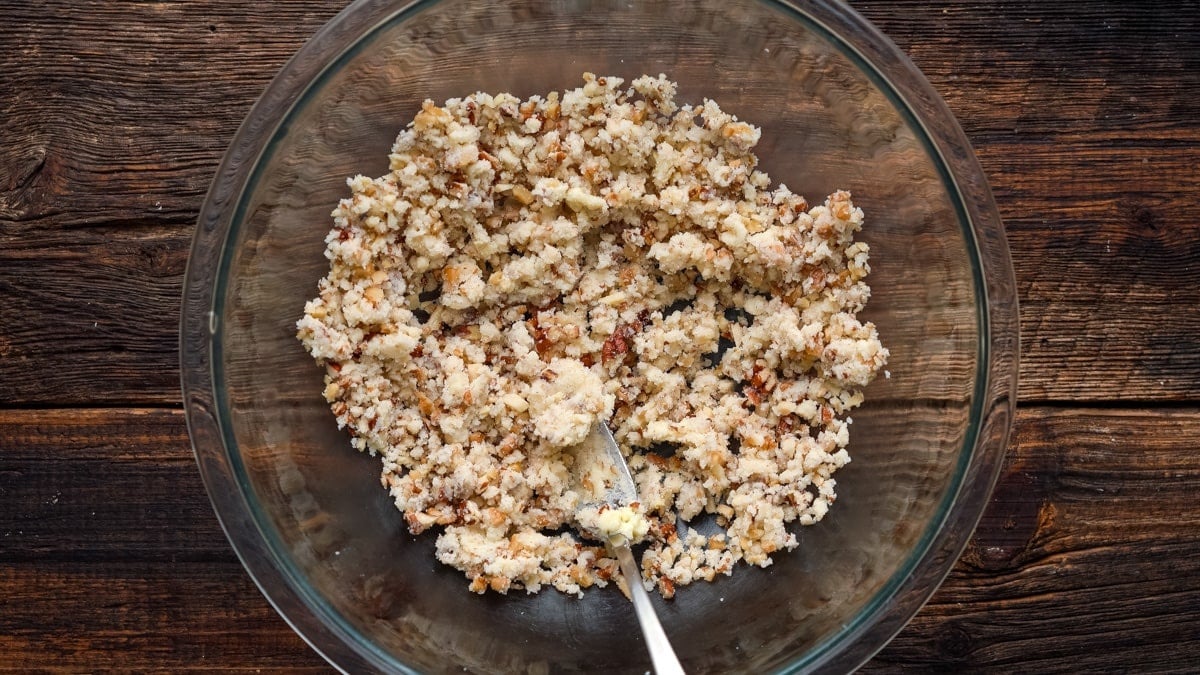 Mixing nuts, butter, and sugar in the bowl.