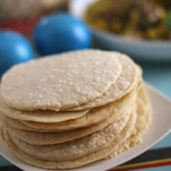 A stack of Homemade Corn Tortillas on a plate.