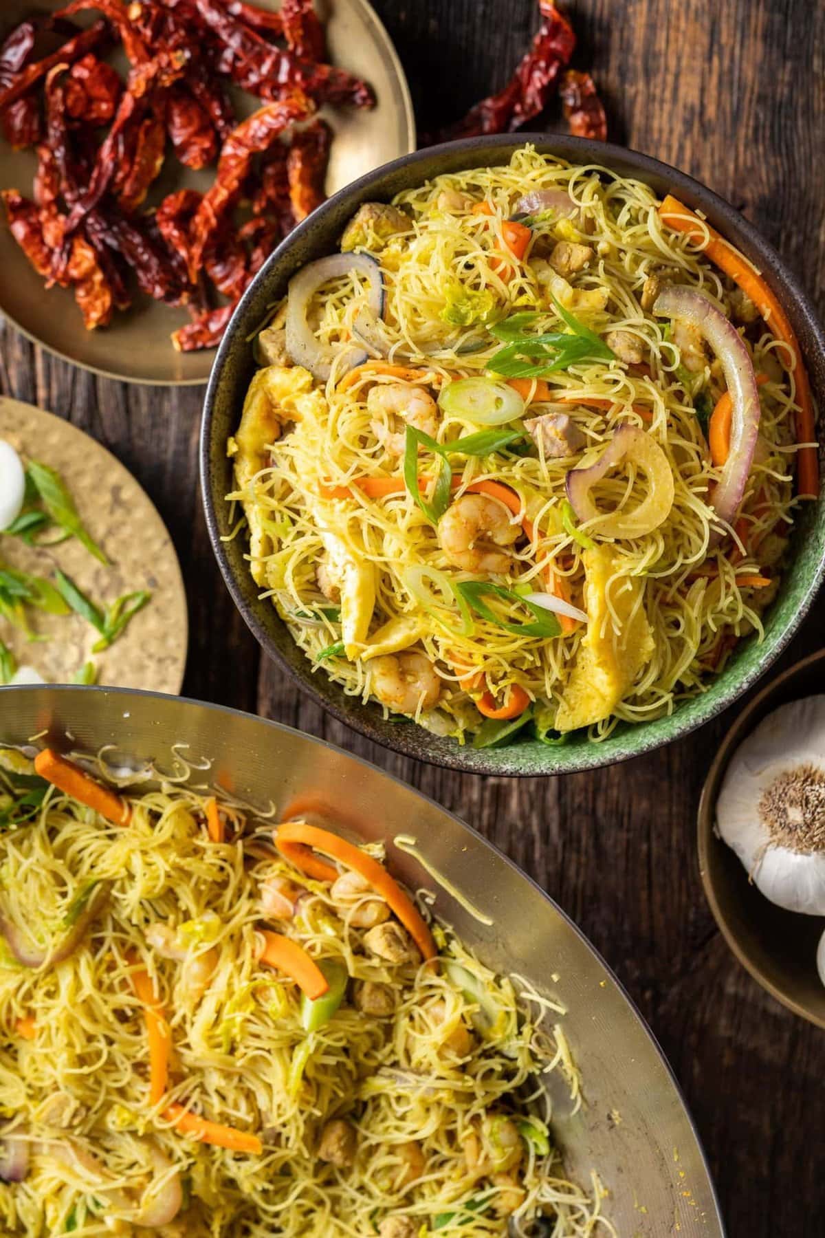 Singapore noodles in a bowl served on a table.