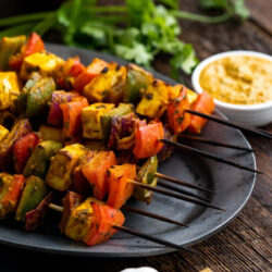 Paneer tikka cheese skewers on a plate.