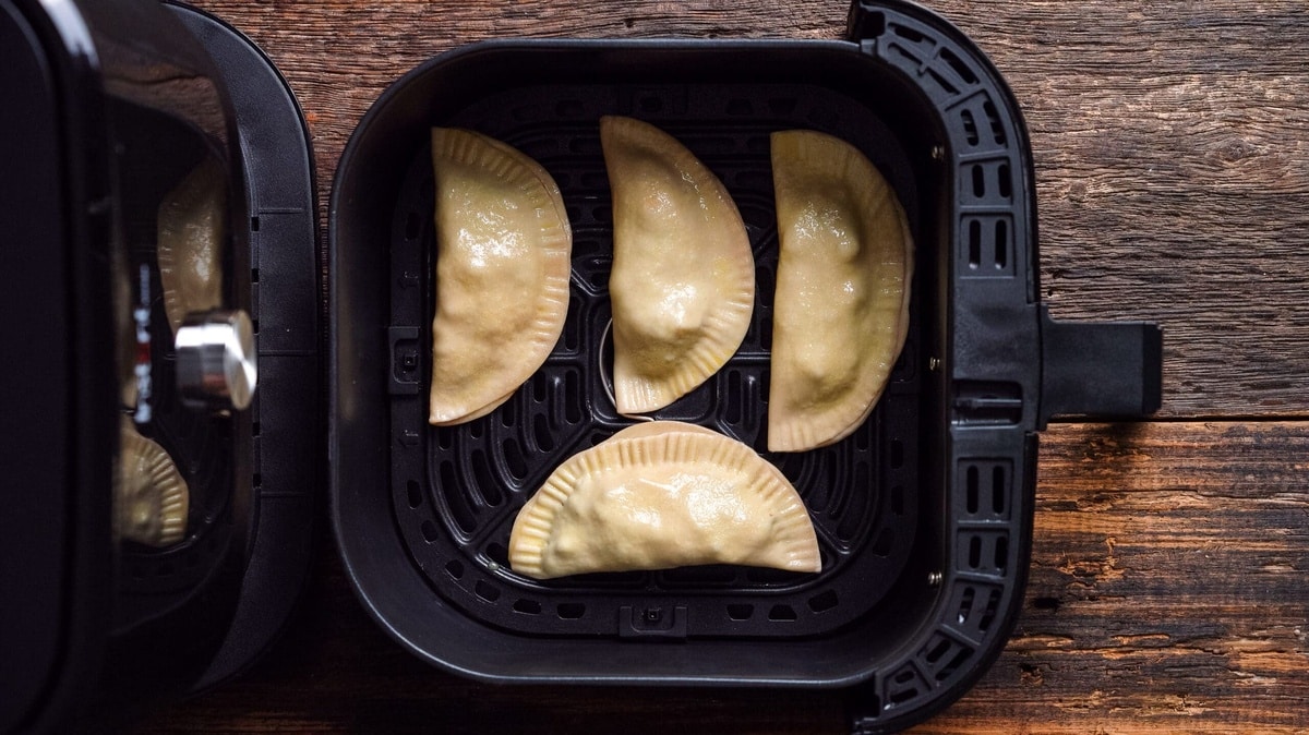 Empanadas cooking in an air fryer.