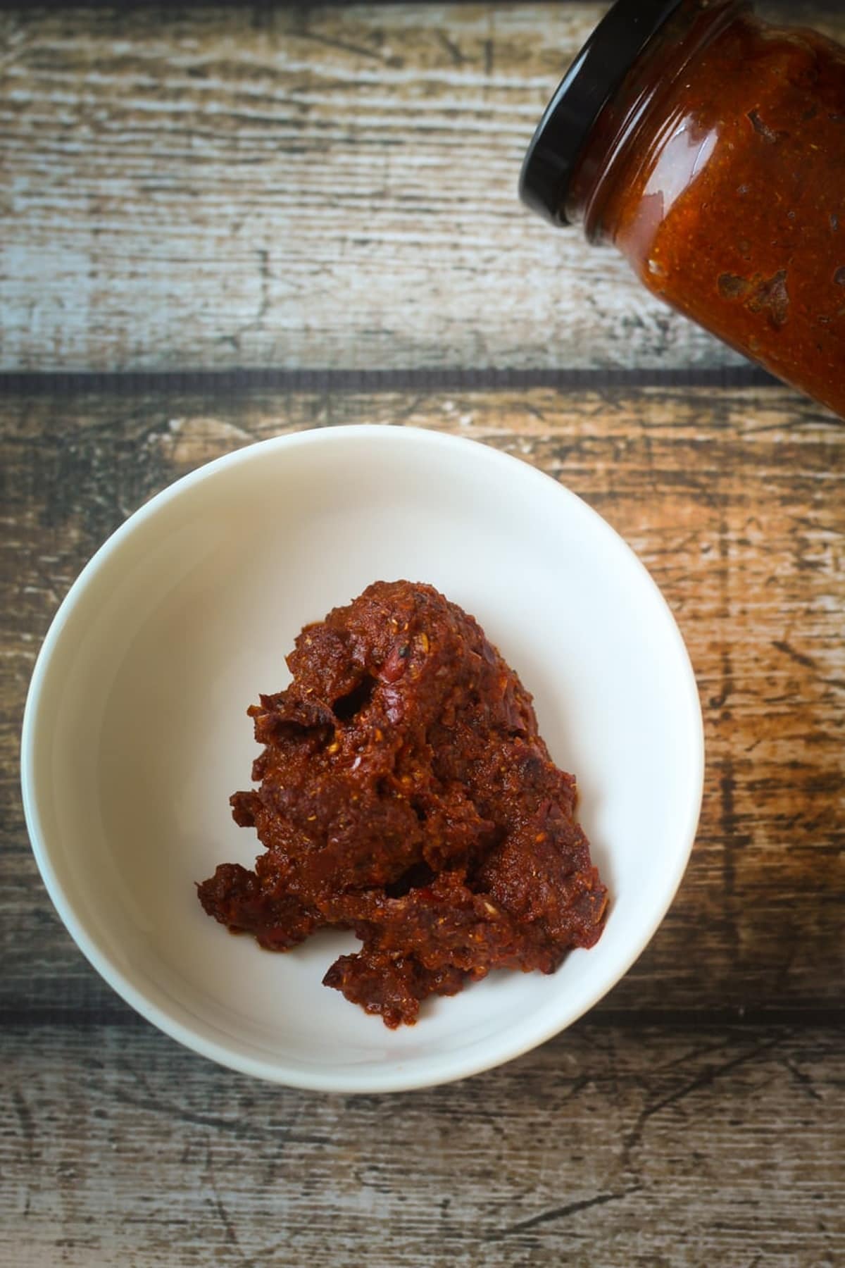 Red curry paste in a bowl, placed on a table.