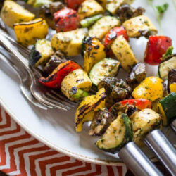 Spicy grilled veggie skewers on a plate.