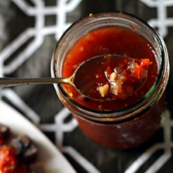 A spoon is partially dipped into the Sweet and Spicy Thai relish.