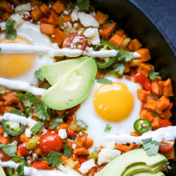 Sweet potato hash with eggs in a cast-iron skillet.