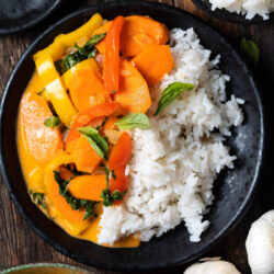 Thai red curry on a plate, served with rice.